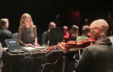 A group of people playing music in a dark room